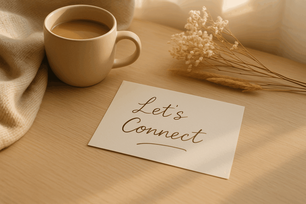 A warm, sunlit workspace with a beige coffee mug, soft blanket, dried flowers, and a handwritten note that reads “Let’s Connect” on a light wooden desk.