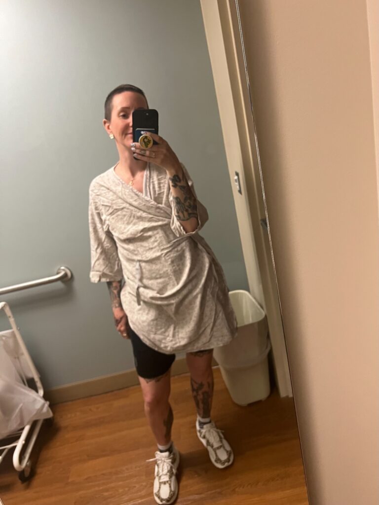 Women standing in hospital gown.